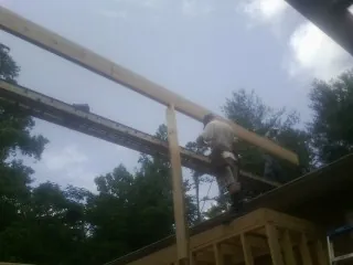 Carpenter setting a ridge beam over a new addition frame — Ice Dam Removal by Roofing Brothers in Ucon