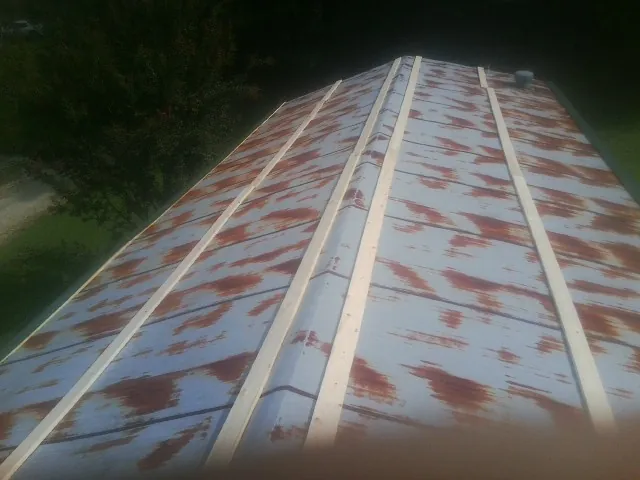 Rusted metal roof panels with new wood purlins before replacement — Storm Damage Roof Repair in Ucon by Roofing Brothers
