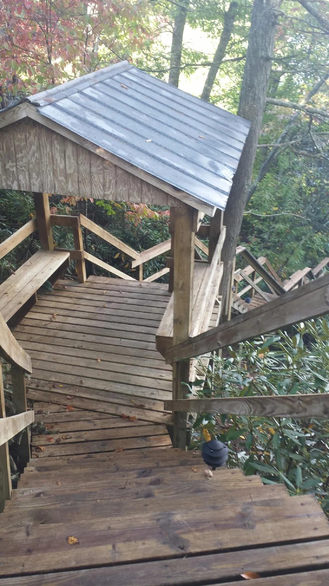 Metal roofed shelter over wooden steps on a wooded walkway — Skylight Repair & Installation work by our crew in Ucon