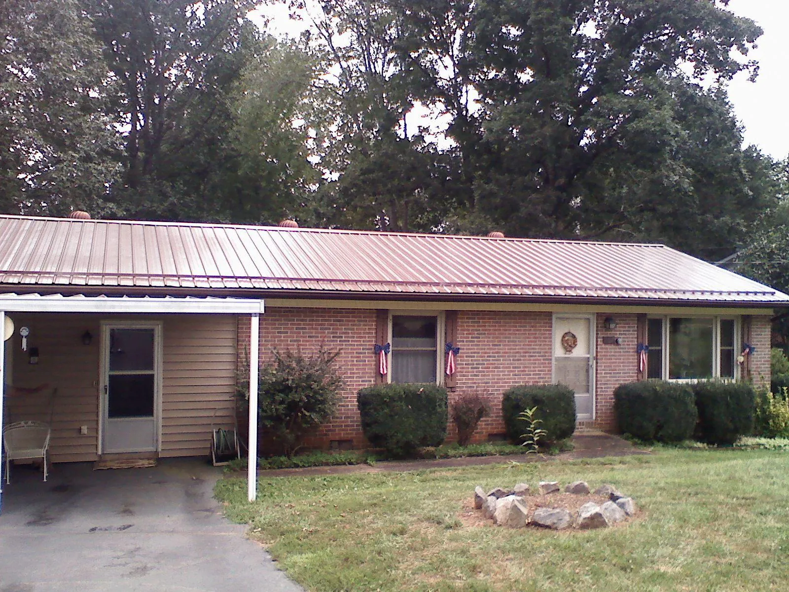Bronze metal roof and carport on a brick ranch home — Roof Repair work by our crew in Ucon